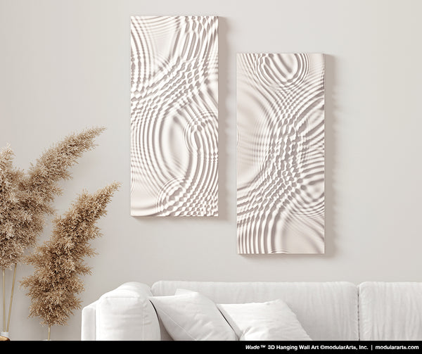 Two textured wall art pieces on a light gray wall with a couch and decorative plants in the foreground.